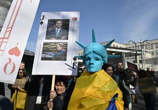 Un manifestante tiene un cartel que representa al vicepresidente de los Estados Unidos, JD Vance, durante una protesta llamada 'América, despierta' frente a la embajada de los Estados Unidos en Kiev